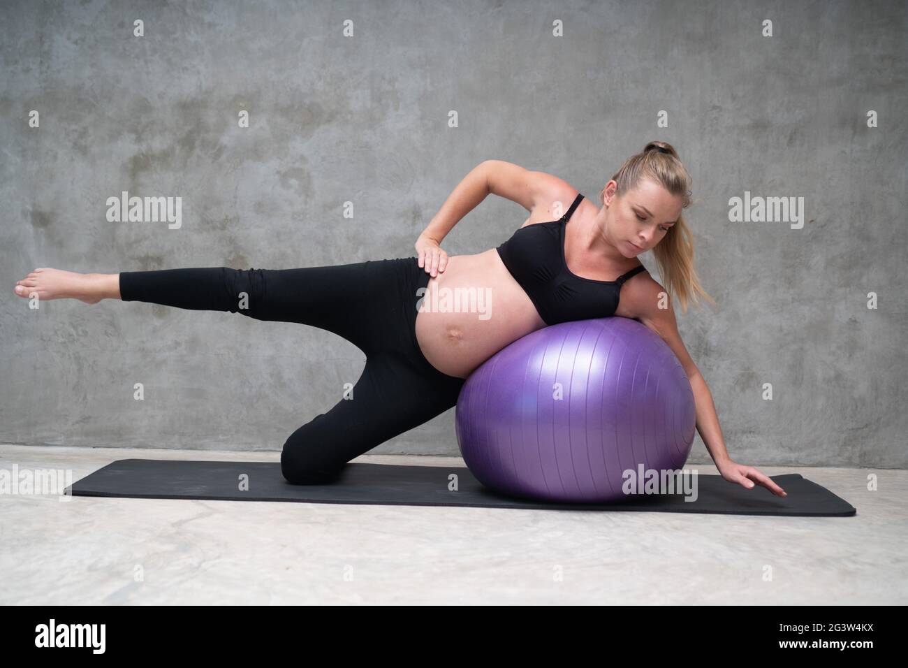 Portrait de jolie femme enceinte exercices avec le fitball dans la salle de gym Banque D'Images