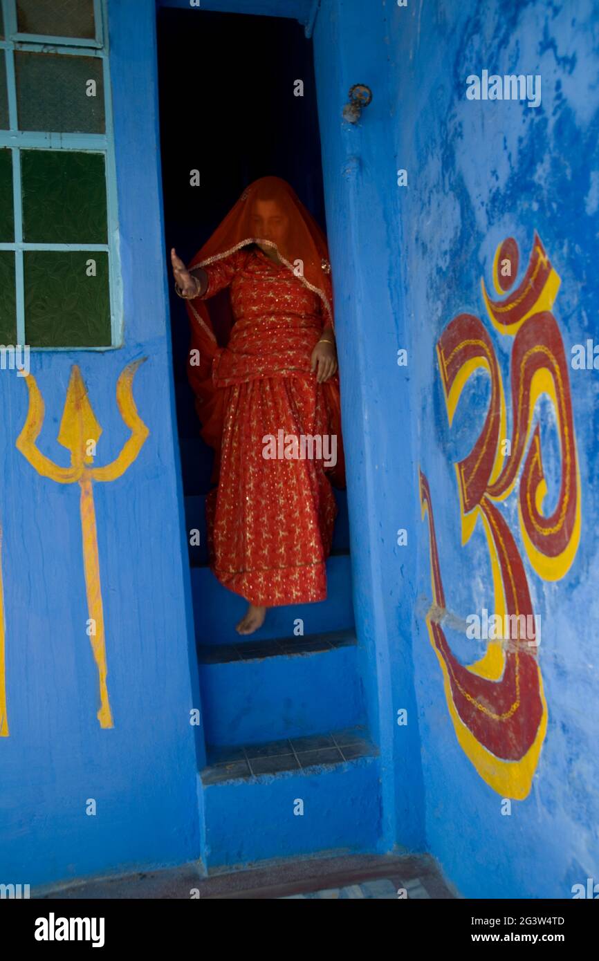 Une jeune femme en voile marchant dans les escaliers d'une maison bleue à l'intérieur de la ville bleue de Jodhpur, Rajasthan, Inde Banque D'Images