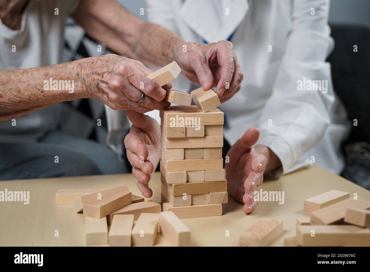 La démence thérapie de manière ludique, l'entraînement des doigts et les compétences fines de moteur, construire des blocs de bois dans la tour, jouant Jenga. Senior W Banque D'Images