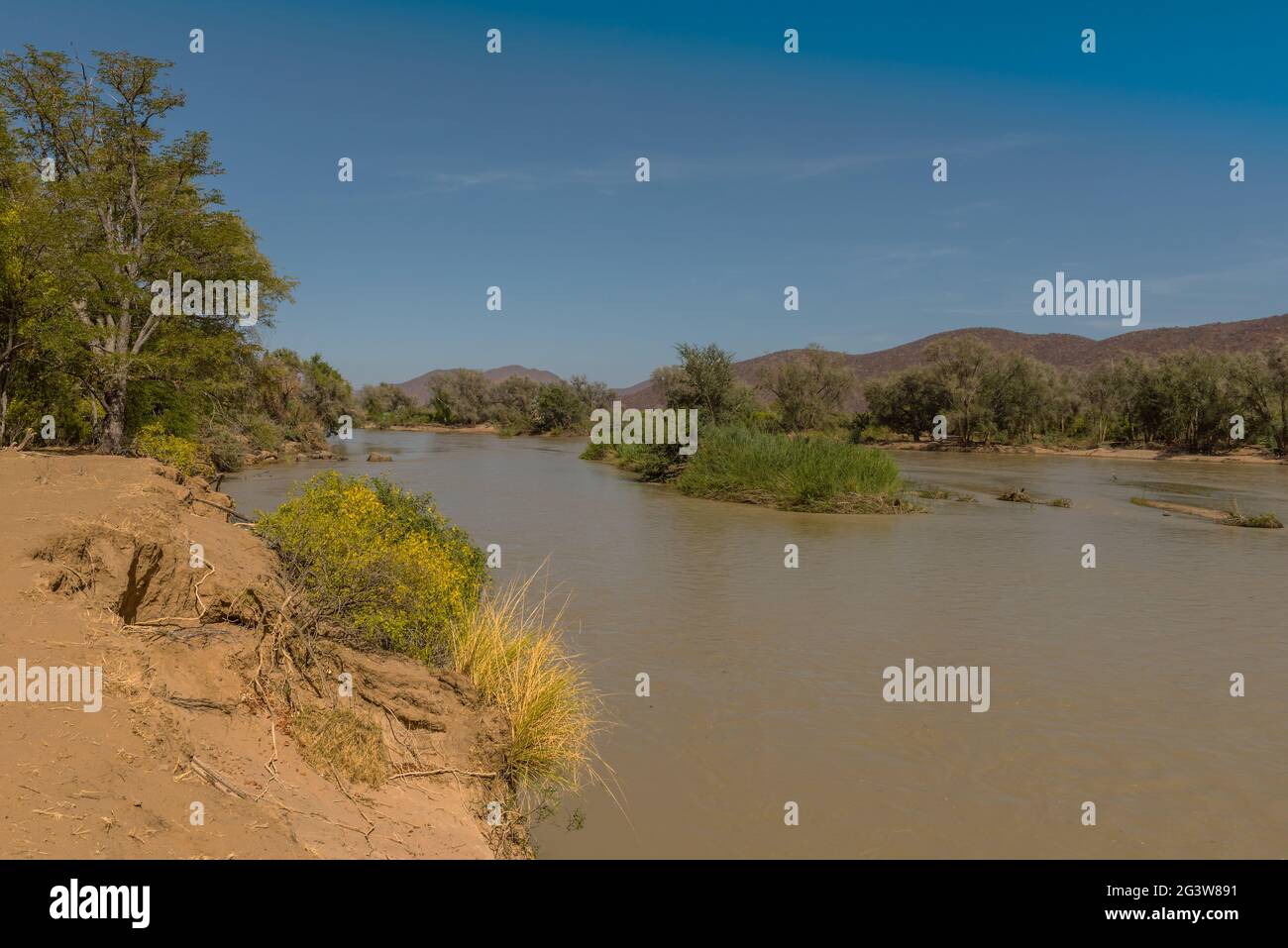 Vue sur le paysage de la rivière Kunene, la rivière frontalière entre la Namibie et l'Angola Banque D'Images