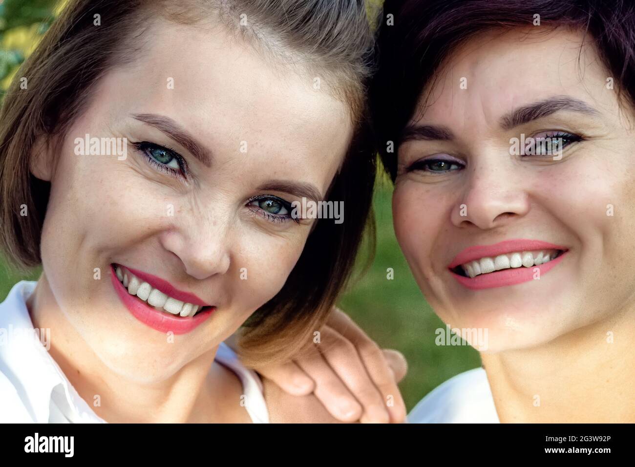 Amitié des femmes. Deux belles femmes d'apparence caucasienne sourient. Portrait en gros plan. Banque D'Images
