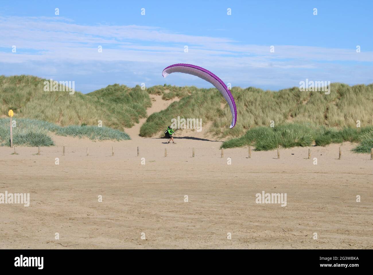 Vue panoramique sur la plage avec des dunes de sable et un parapente au loin avec l'espace de copie Banque D'Images