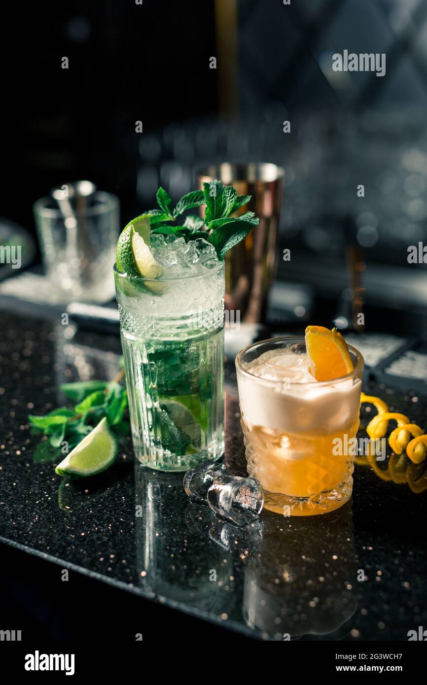 Plusieurs cocktails alcoolisés au bar dans différents verres. Décoration cocktail : citron vert, menthe, orange Banque D'Images