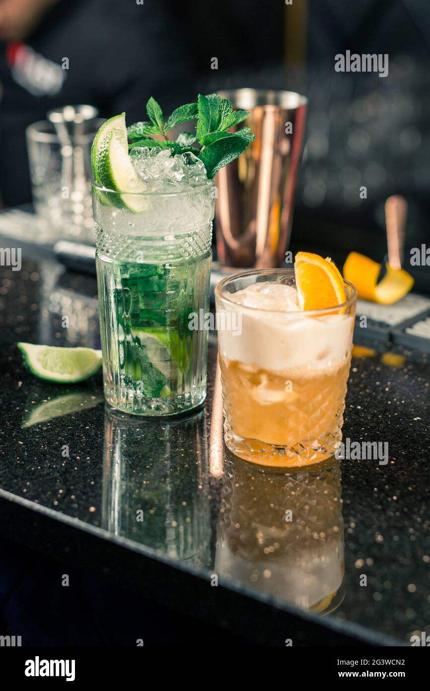 Plusieurs cocktails alcoolisés au bar dans différents verres. Décoration cocktail : citron vert, menthe, orange Banque D'Images