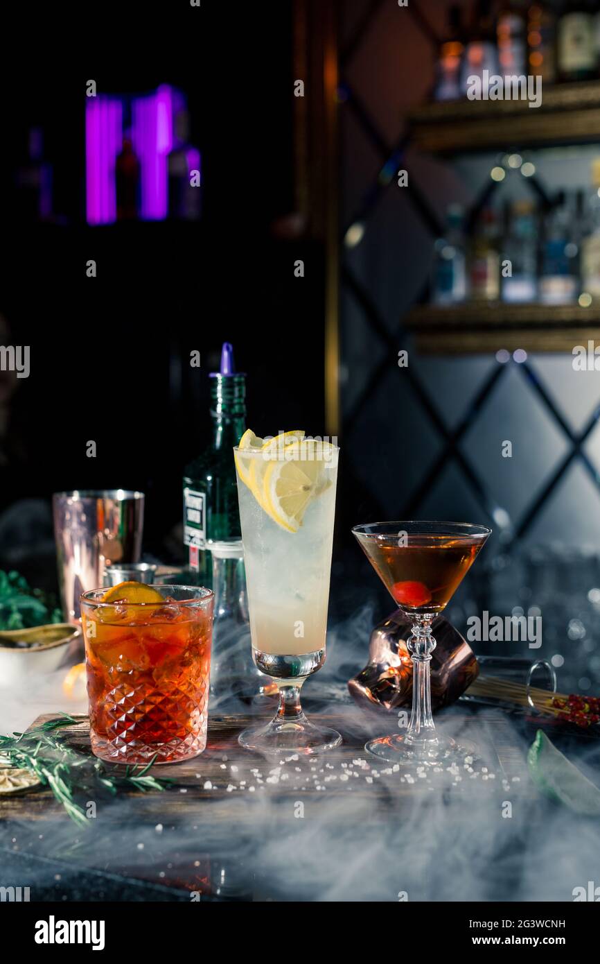 Plusieurs cocktails alcoolisés au bar dans différents verres. Décoration cocktail : citron vert, menthe, orange Banque D'Images