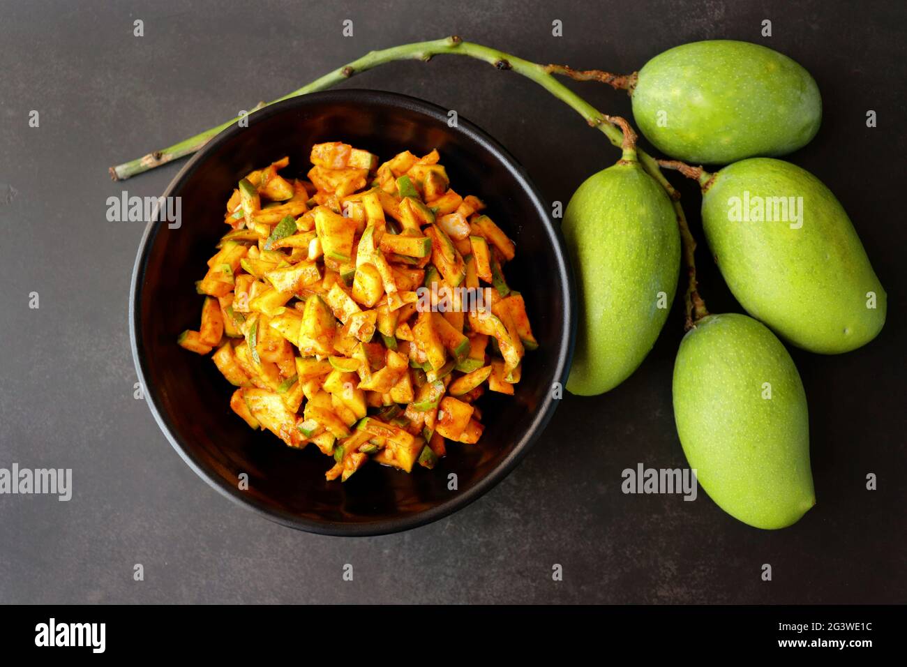 Salade de mangue verte. Pickle instantané à la mangue crue. Également connu sous le nom de kairi koshimbir à Marathi. Copier l'espace sur fond noir. Mangues vertes hachées. Banque D'Images