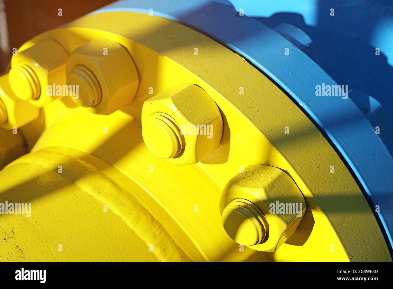 Deux tuyaux de gaz bleu et jaune sont reliés par de grands boulons et écrous. Contexte pour les fournisseurs de produits et de tuyaux de gaz. Banque D'Images