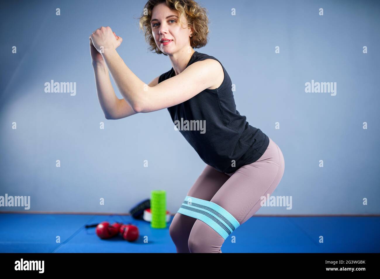 Jambes femme pieds nus faisant de l'exercice pilates avec élastique tissu résistance bande. Bandes de résistance pour le bout et les jambes, interdiction d'exercice Banque D'Images