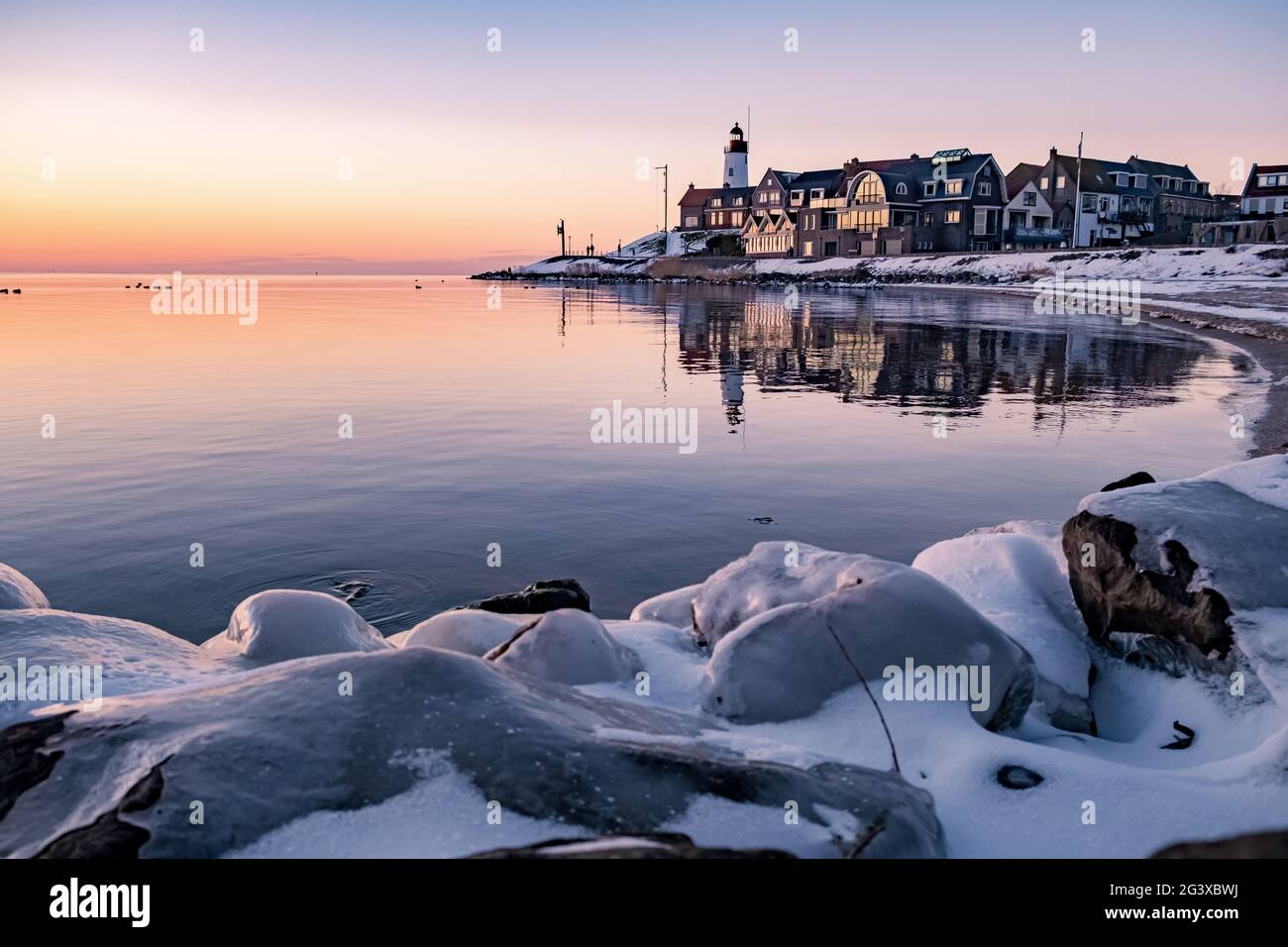 Hiver à Urk avec la digue et la plage près du phare d'Urk neige couverte pendant l'hiver, coucher de soleil par le phare d'Urk Flevo Banque D'Images