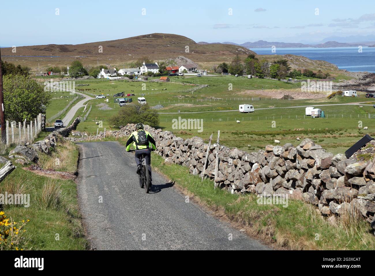 Cycliste en direction de la petite colonie de Mellon Udrigle, côte nord-ouest de l'Écosse, Royaume-Uni Banque D'Images