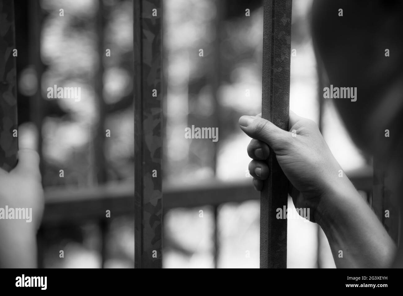 Cellule de prison : gros plan des mains en prison Banque D'Images