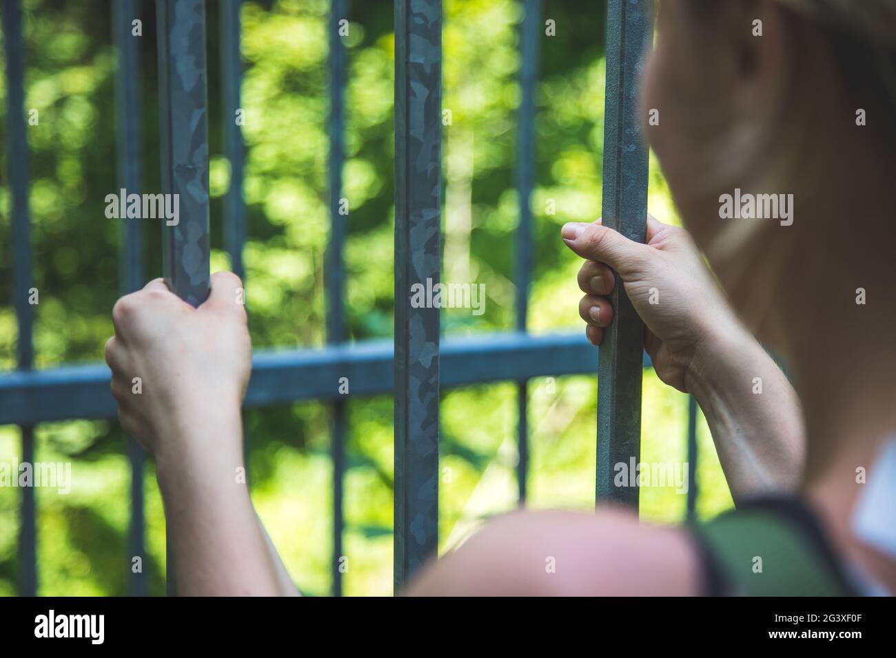Cellule de prison : gros plan des mains en prison Banque D'Images