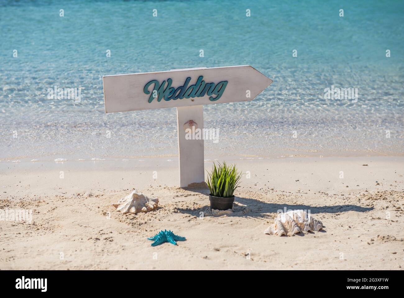 Gros plan du signe de mariage sur une plage de sable de l'île tropicale paradisiaque de l'océan avec en arrière-plan Banque D'Images