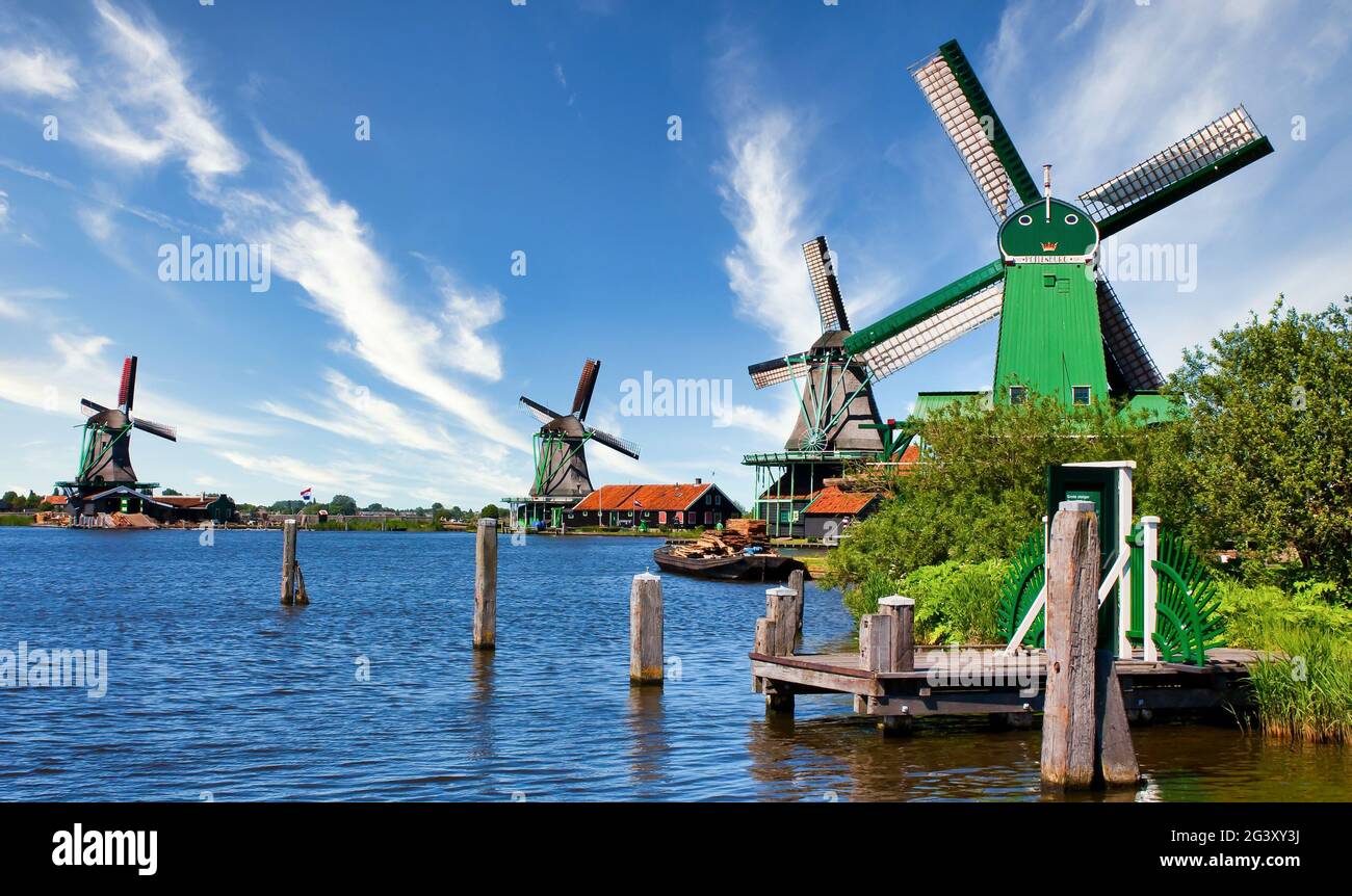 Moulin à vent hollandais dans la campagne verte près d'Amsterdam, pays-Bas, avec ciel bleu et eau de rivière. Banque D'Images