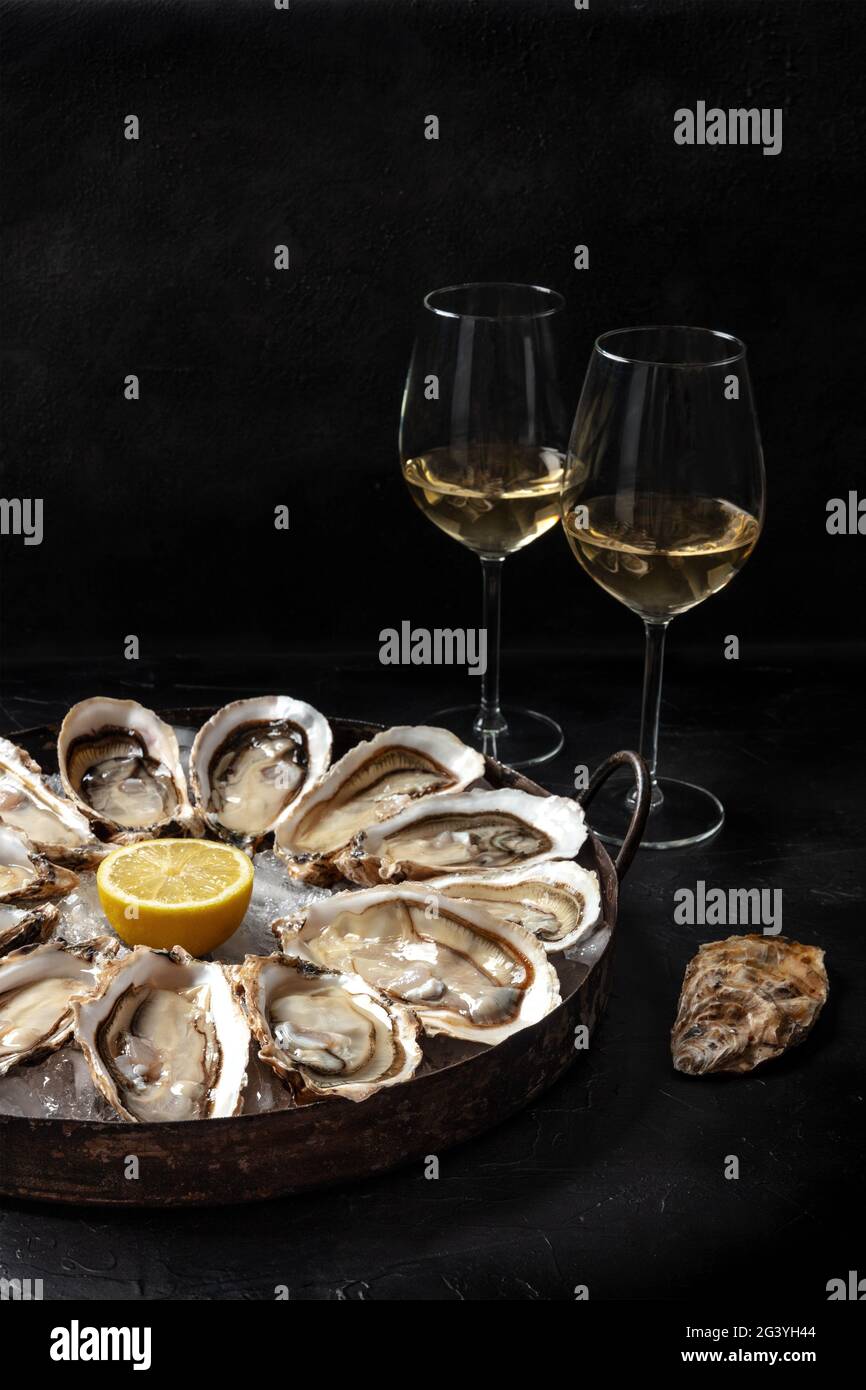 Huîtres sur un plateau, avec citron et vin Banque D'Images