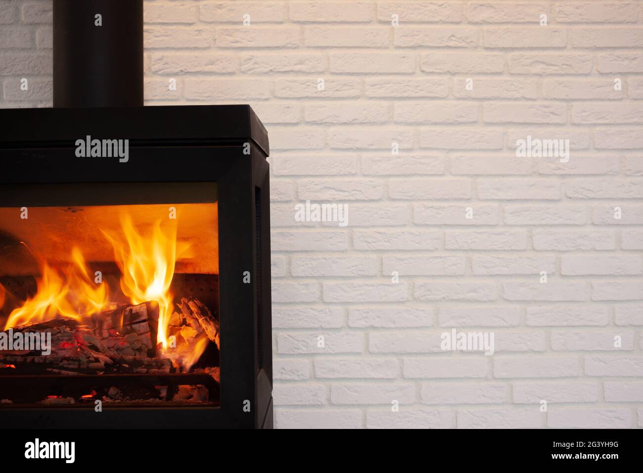 Cheminée moderne en fonte avec fond de briques blanches Banque D'Images