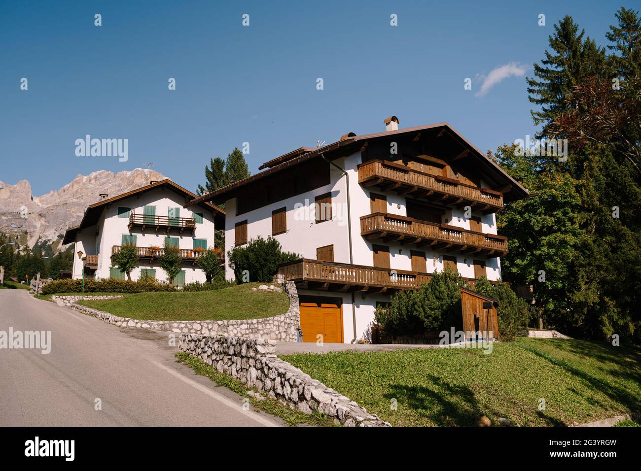 Maisons blanches et montagnes rocheuses avec forêt dense de verdure dans les Dolomites dans le Tyrol du Sud, Italie. Cortina Ampezzo est une ville italienne Banque D'Images