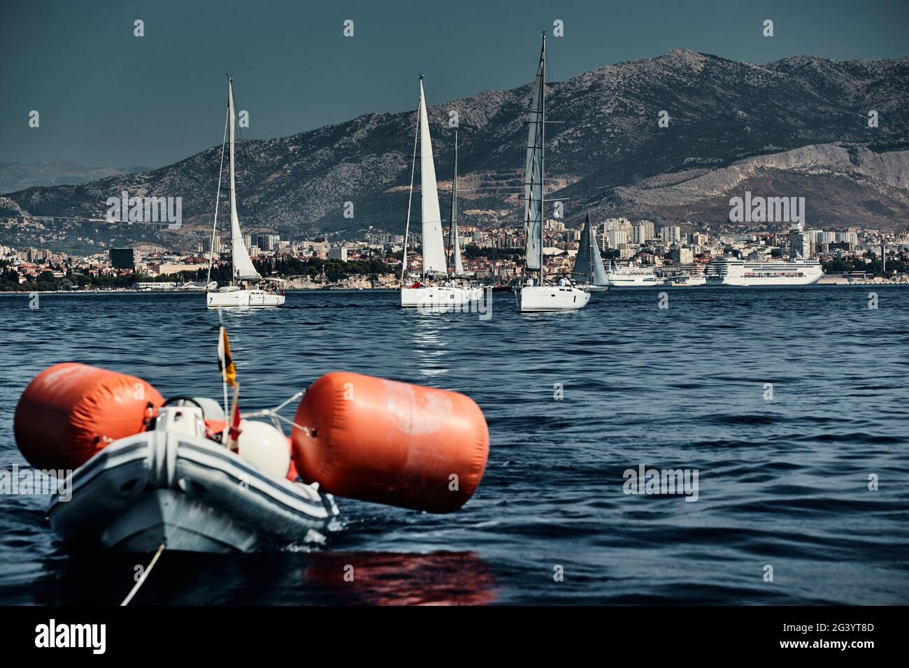 Le bateau en caoutchouc des organisateurs d'une régate avec le juge et ballon de couleur orange, la course des voiliers, compétition intense Banque D'Images