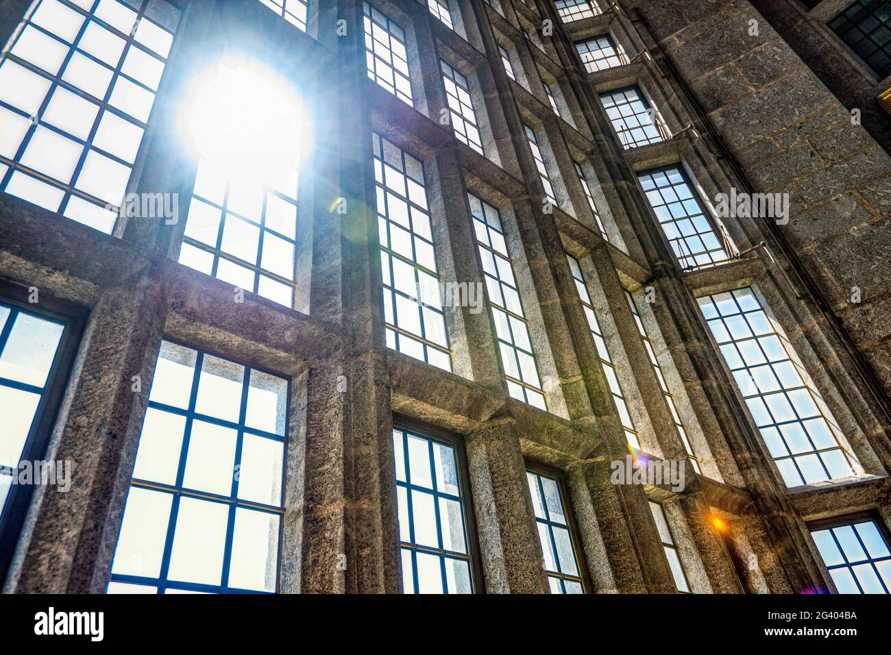 La lumière du soleil se diffuse à travers les grandes fenêtres du château des années 1920 de Drogo, Devon, Royaume-Uni Banque D'Images