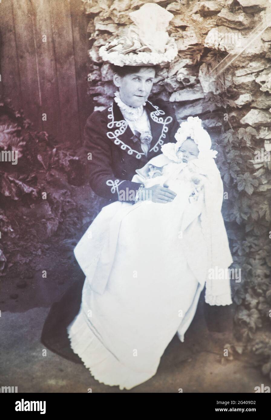 Début du XXe siècle authentique photo vintage de mère tenant bébé assis dans le jardin. Concept de l'entretien, de la compassion, de l'amour, de la convivialité, de la nostalgie Banque D'Images