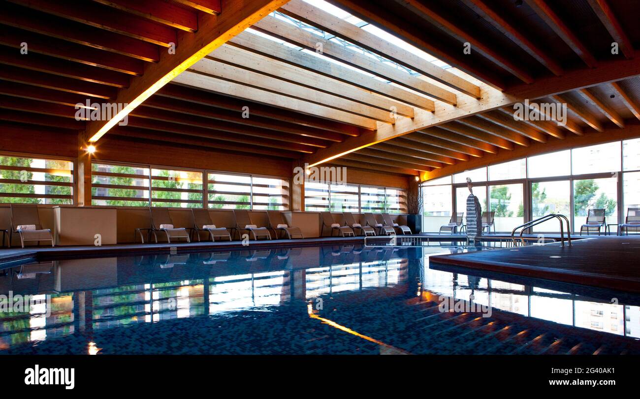 Piscine intérieure, avec éclairage sur le toit et grandes fenêtres illuminant la structure en bois, Madrid, Espagne. Banque D'Images