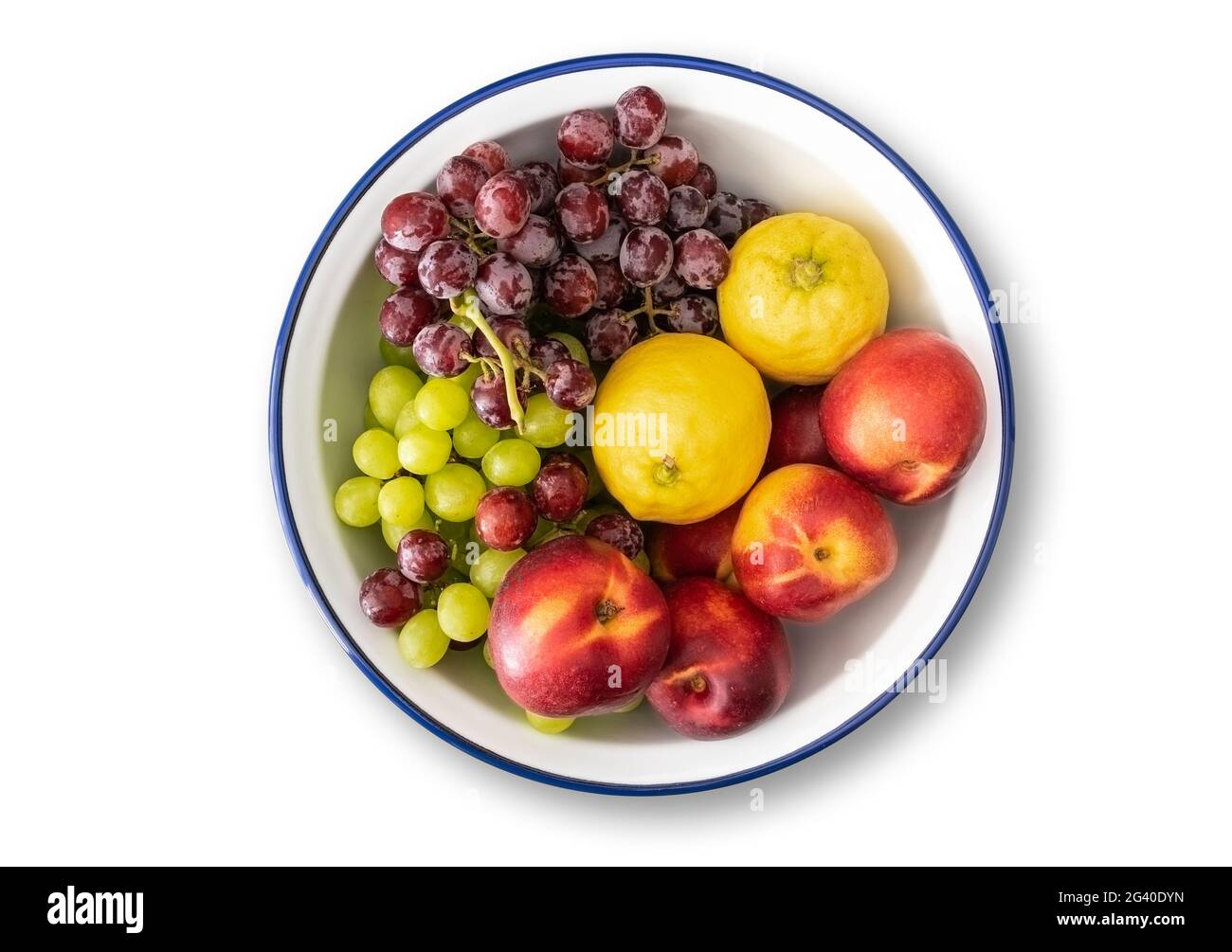 vue de dessus d'un bol en émail blanc avec bord bleu rempli de fruits frais isolés sur fond blanc Banque D'Images