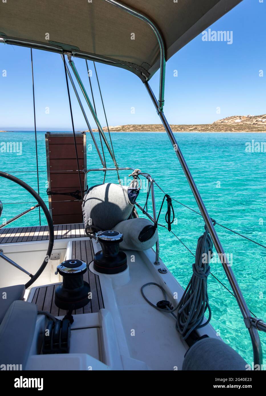 Bateau à voile à la poupe, bleu turquoise fond d'eau de mer, roue, cale,  ailes et treuil sur la partie arrière du pont du voilier, croisière d'été  dans la mer Égée GR