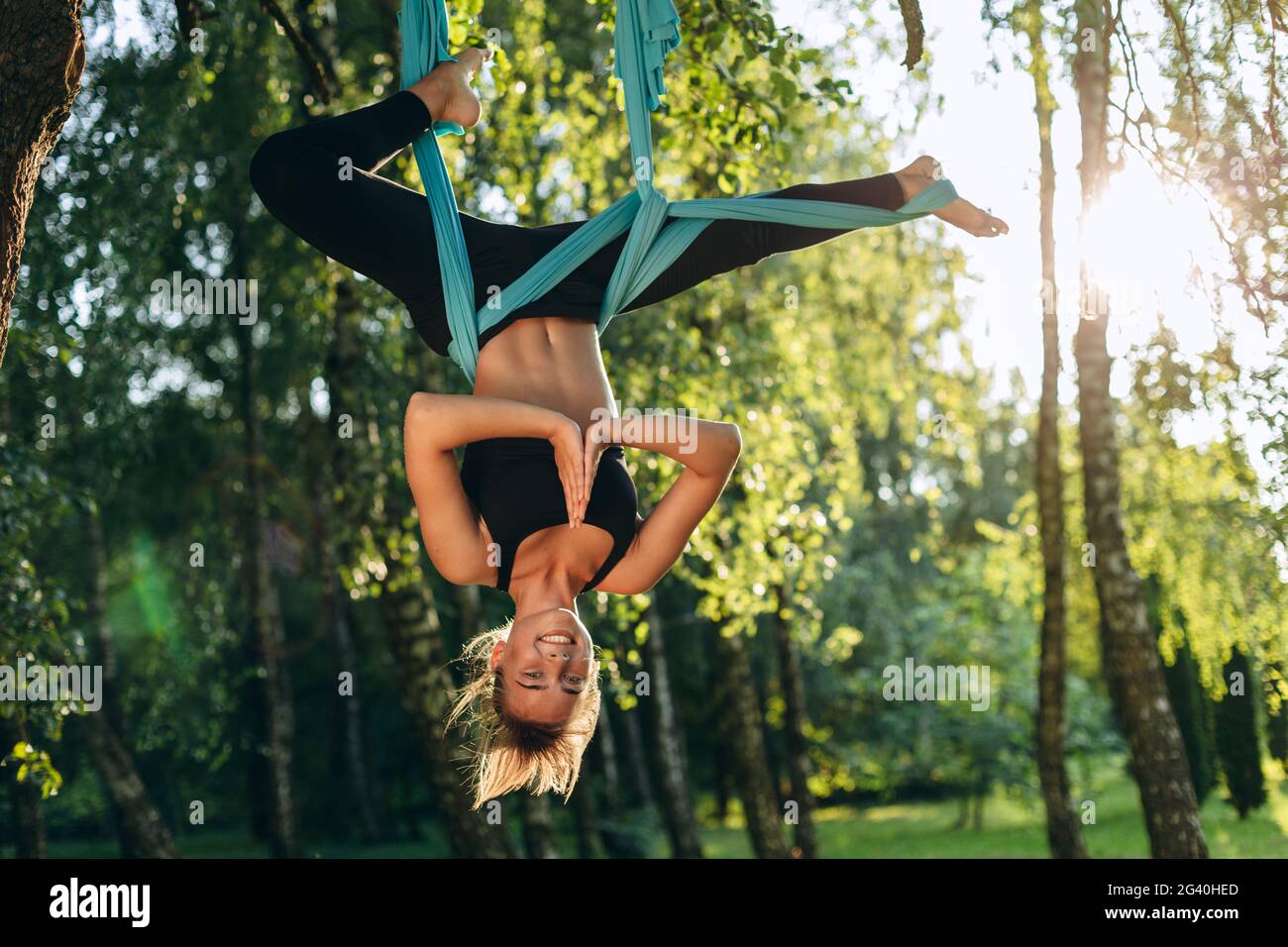 Belle fille pratiquant le yoga sur un arbre. Concept de santé, sport, yoga. La gymnastique effectue des exercices physiques. Banque D'Images