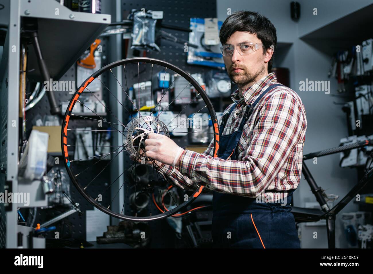 Mécanicien de vélo fixant la roue de cycle dans l'atelier de réparation. Service de Velociede. Réparateur agréé, technicien d'atelier de vélo, réparation de la roue de vélo dans le cas où Banque D'Images