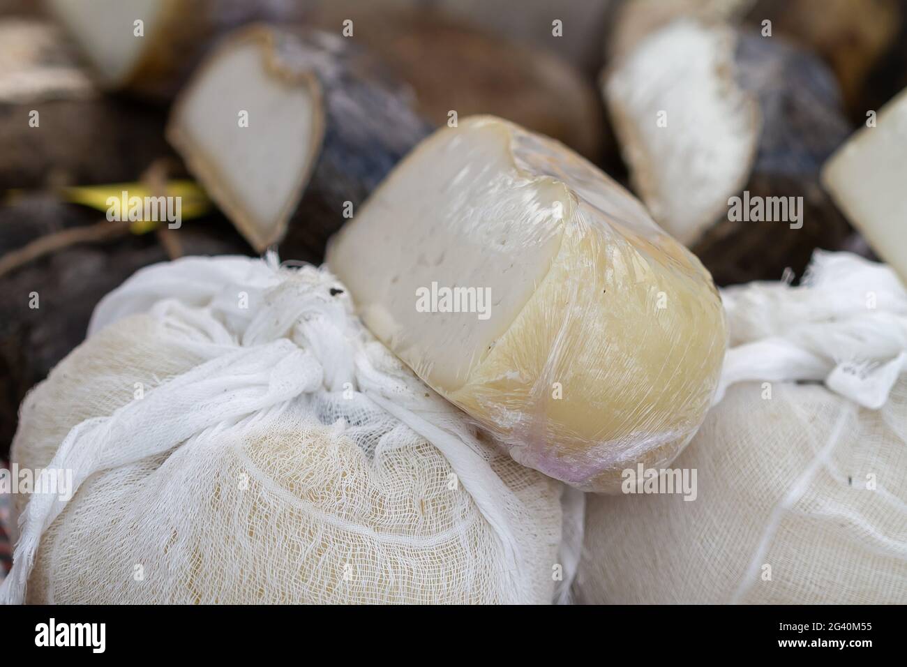 Gros plan de fromage de chèvre enveloppé de tissu et de plastique Banque D'Images