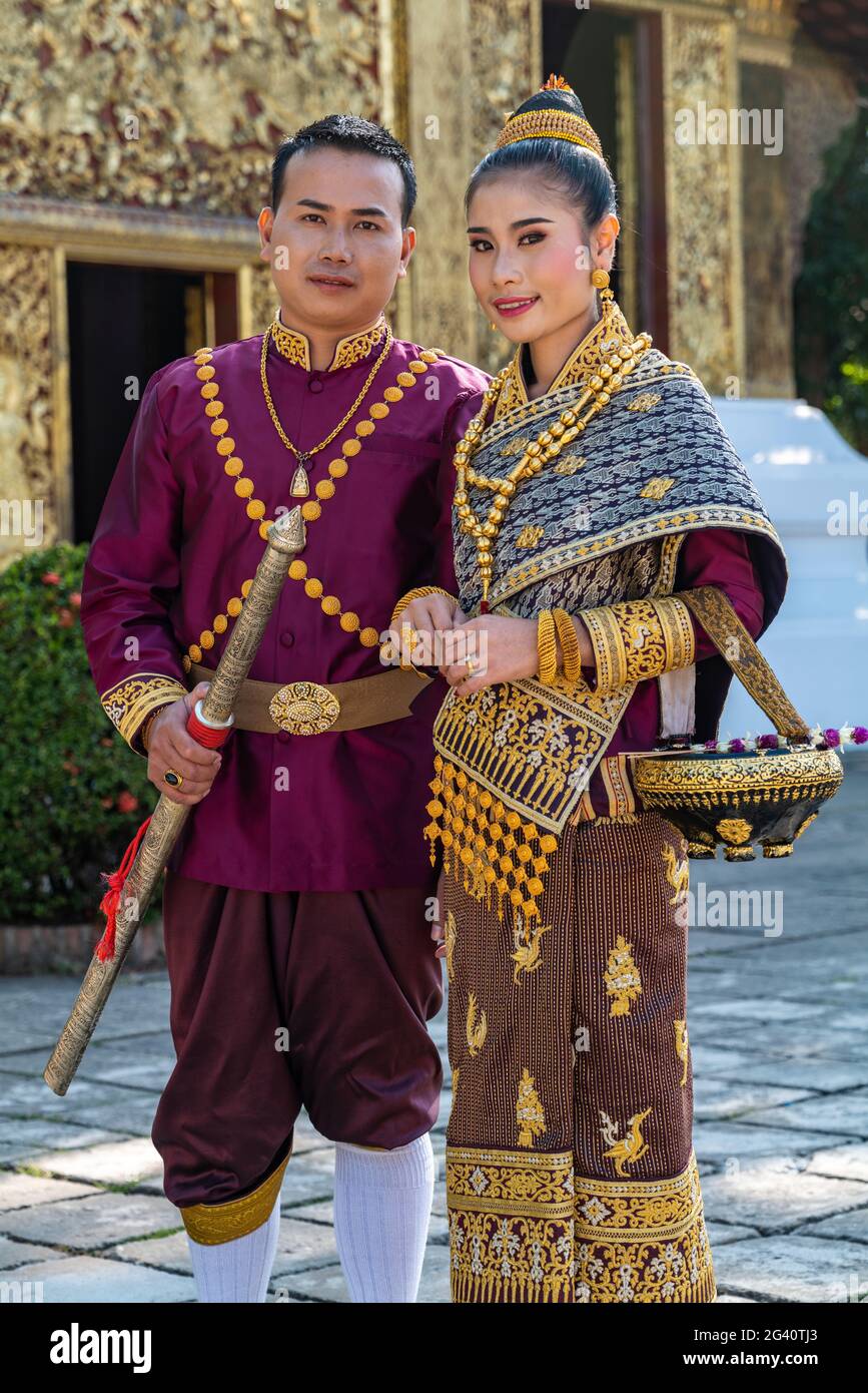 Couple de mariage heureux dans une magnifique tenue de mariage laotienne pendant la séance photo au Temple Wat Xieng Thong, Luang Prabang, province de Luang Prabang, Laos, ASI Banque D'Images