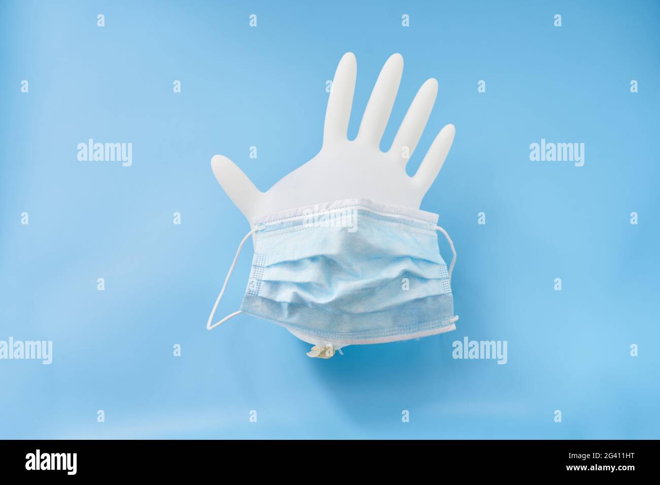 Gant isolé et masque facial sur fond bleu. Arrêter le virus corona Banque D'Images