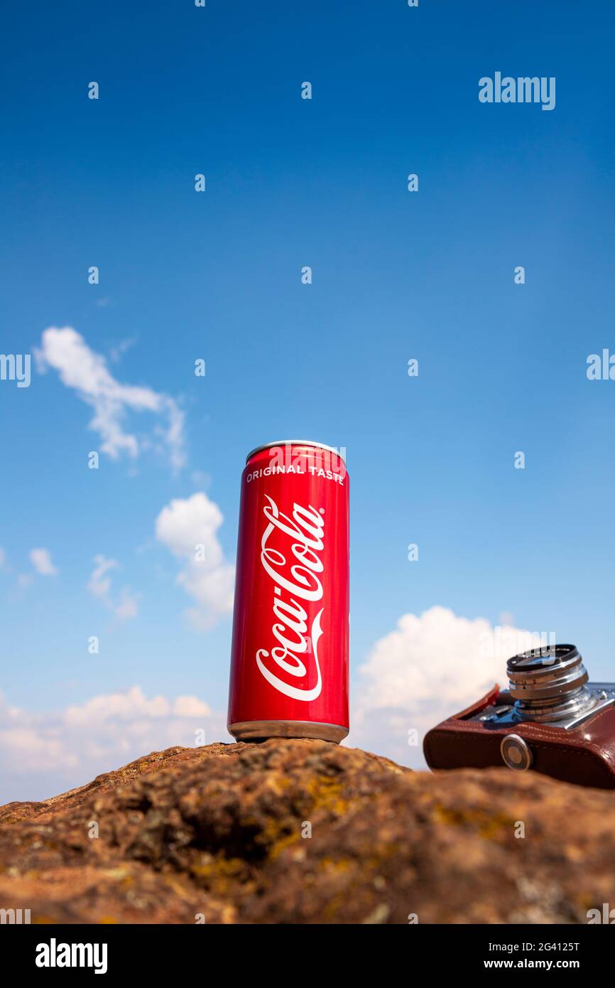 Coca-Cola CAN et appareil photo d'époque reposant sur le rocher au sommet de la montagne. Rédactionnel Banque D'Images
