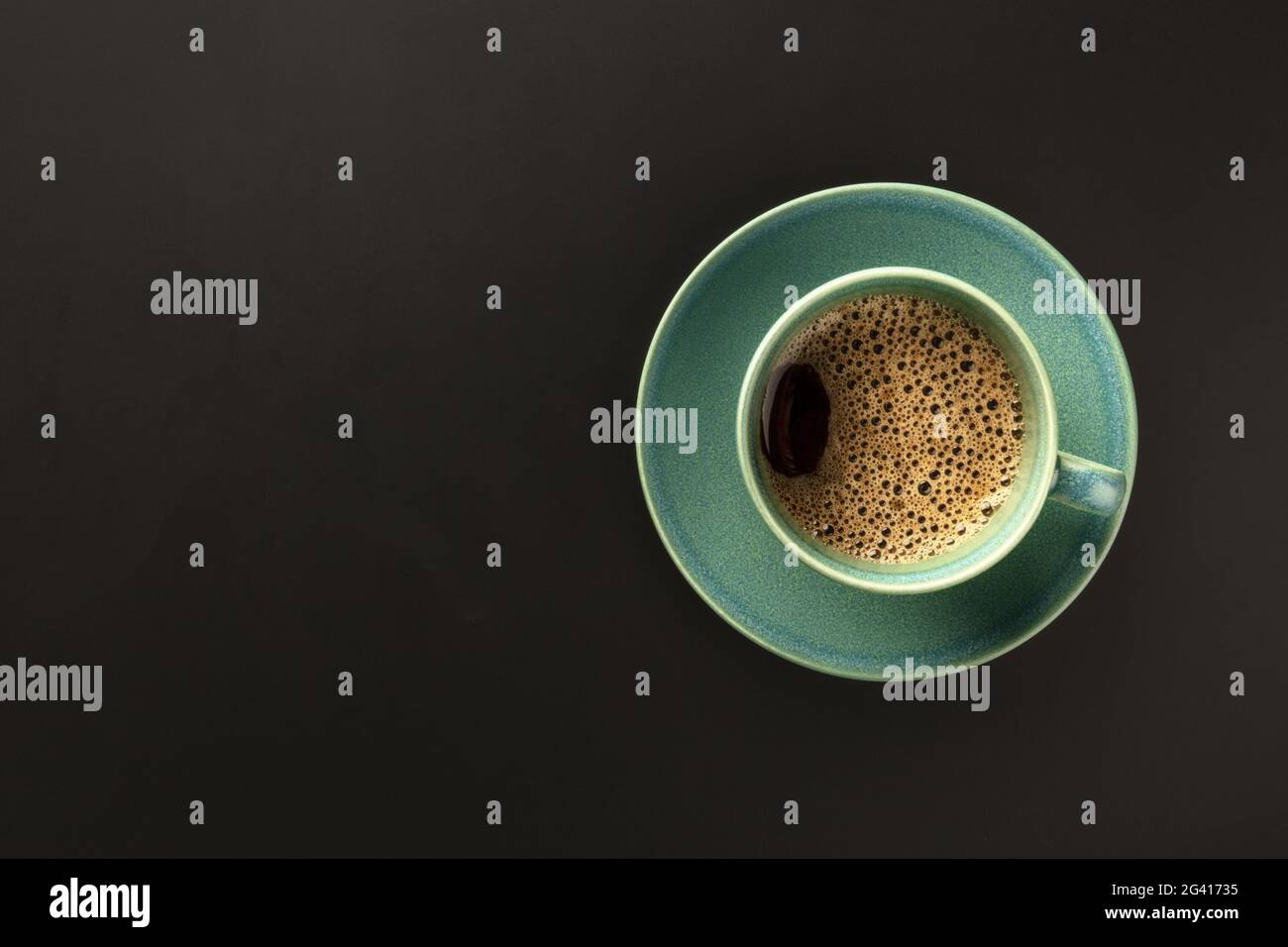 Une tasse de café sur fond noir, prise par le dessus avec Banque D'Images