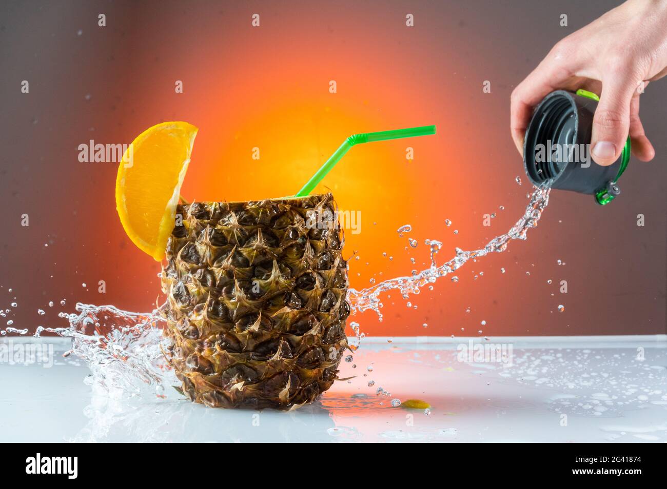 Enregistrement des déversements d'eau dans les coulisses. Vaporisez un cocktail. Derrière la scène d'un tournage commercial. Versez de l'eau sur l'ananas. Banque D'Images