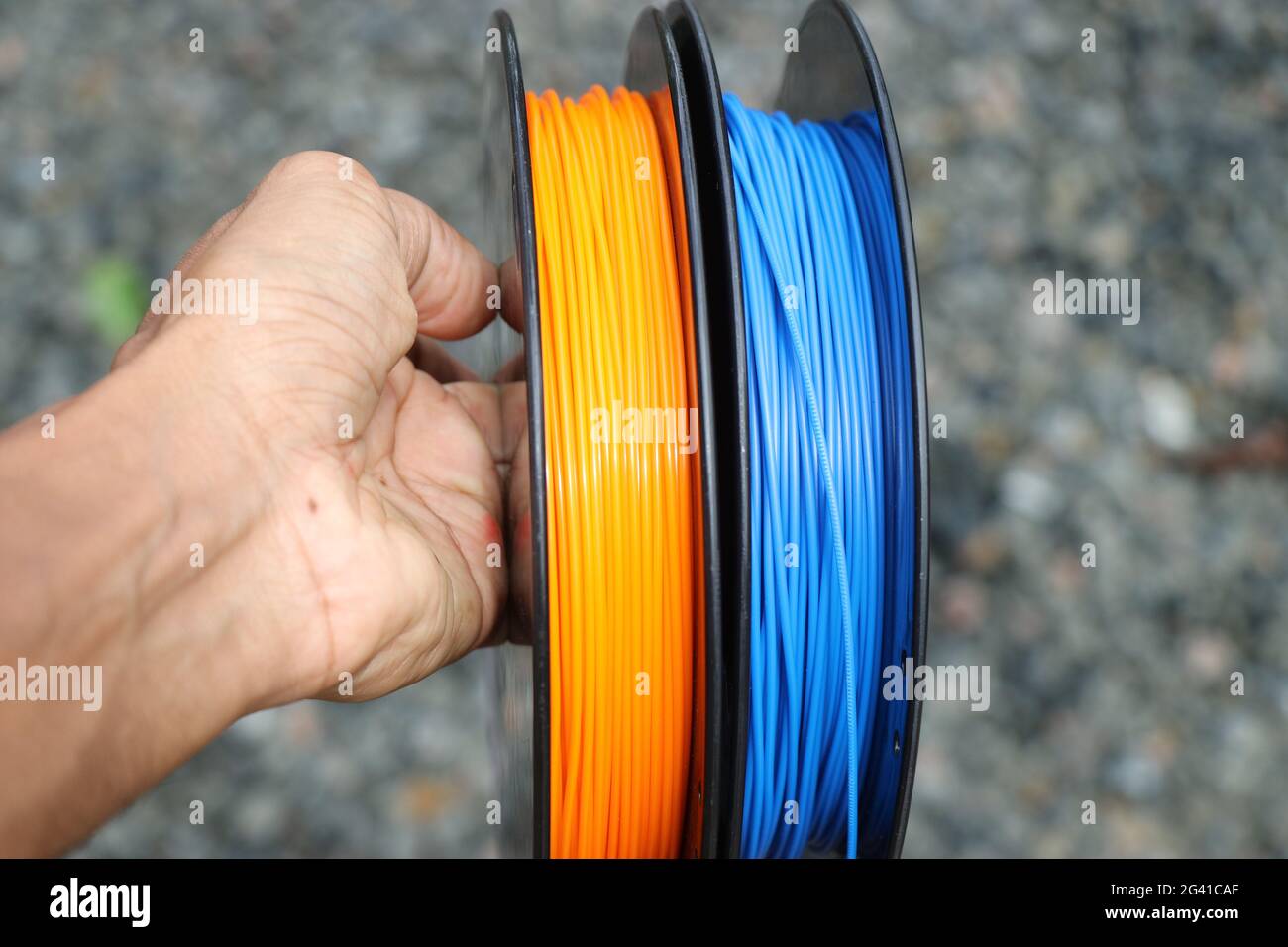 Filament pour imprimante 3d tenu à la main. L'utilisation du matériel pour faire ceci est de l'acide polylactique ou polylactide en bref appelé filament PLA. Banque D'Images