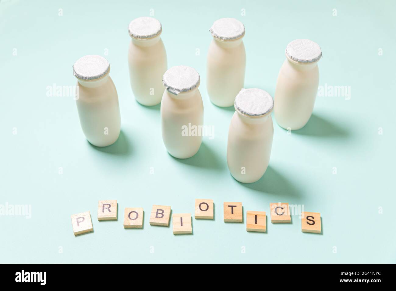 Petits flacons avec probiotiques et prébiotiques boisson laitière sur fond bleu. Production avec des additifs biologiquement actifs. Fermentation et régime guérir Banque D'Images