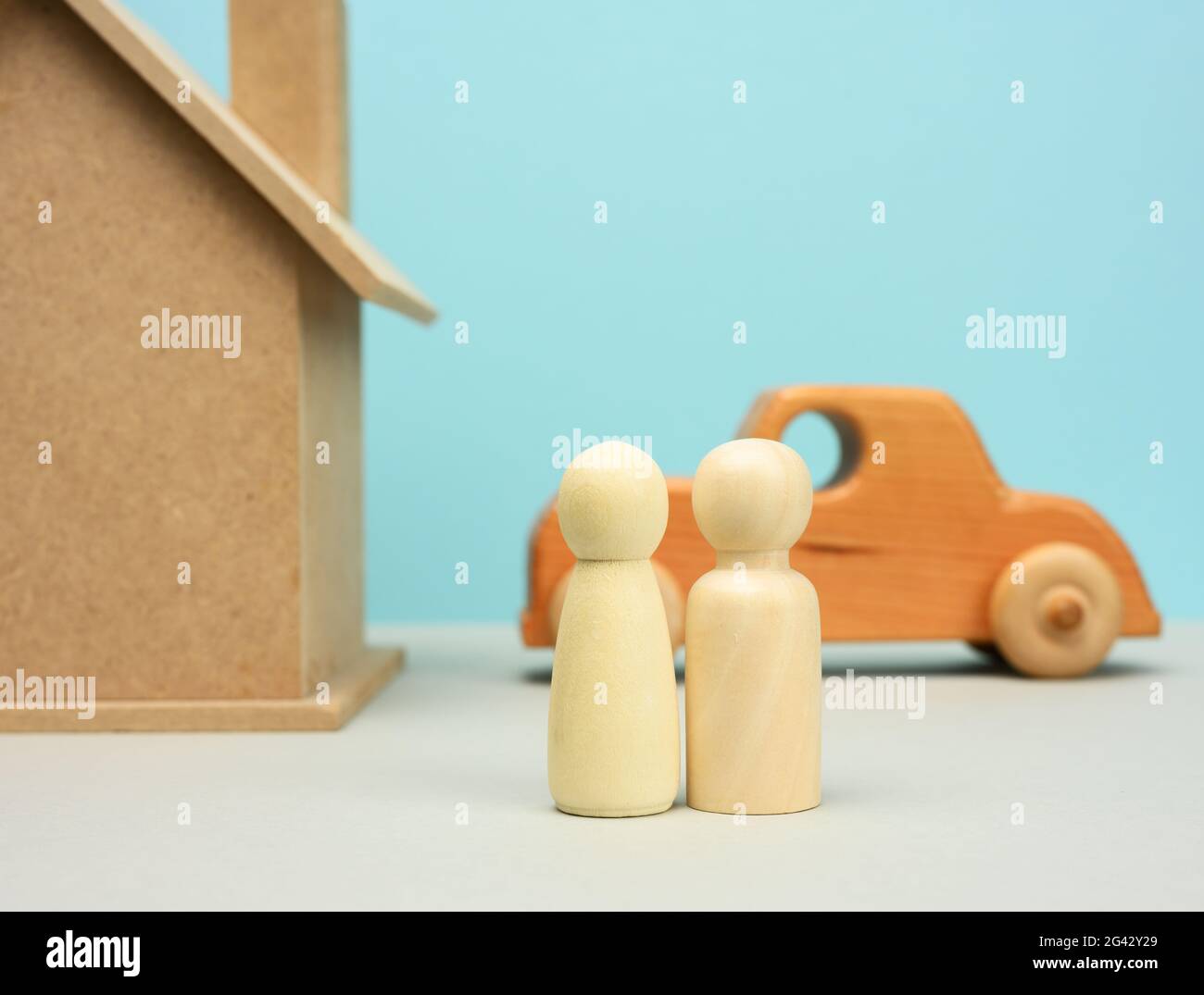 Maison en bois et voiture avec des figurines de famille miniatures, concept d'hypothèque et de prêt Banque D'Images