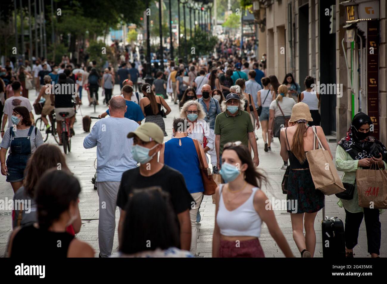 En ce vendredi après-midi, les gens portant des masques pour empêcher la propagation du coronavirus marchent dans la rue commerçante Portal del Angel à Barcelone. L'utilisation obligatoire en Espagne de masques extérieurs prendra fin le 26 juin, a déclaré aujourd'hui le Premier ministre espagnol Pedro Sanchez. Banque D'Images