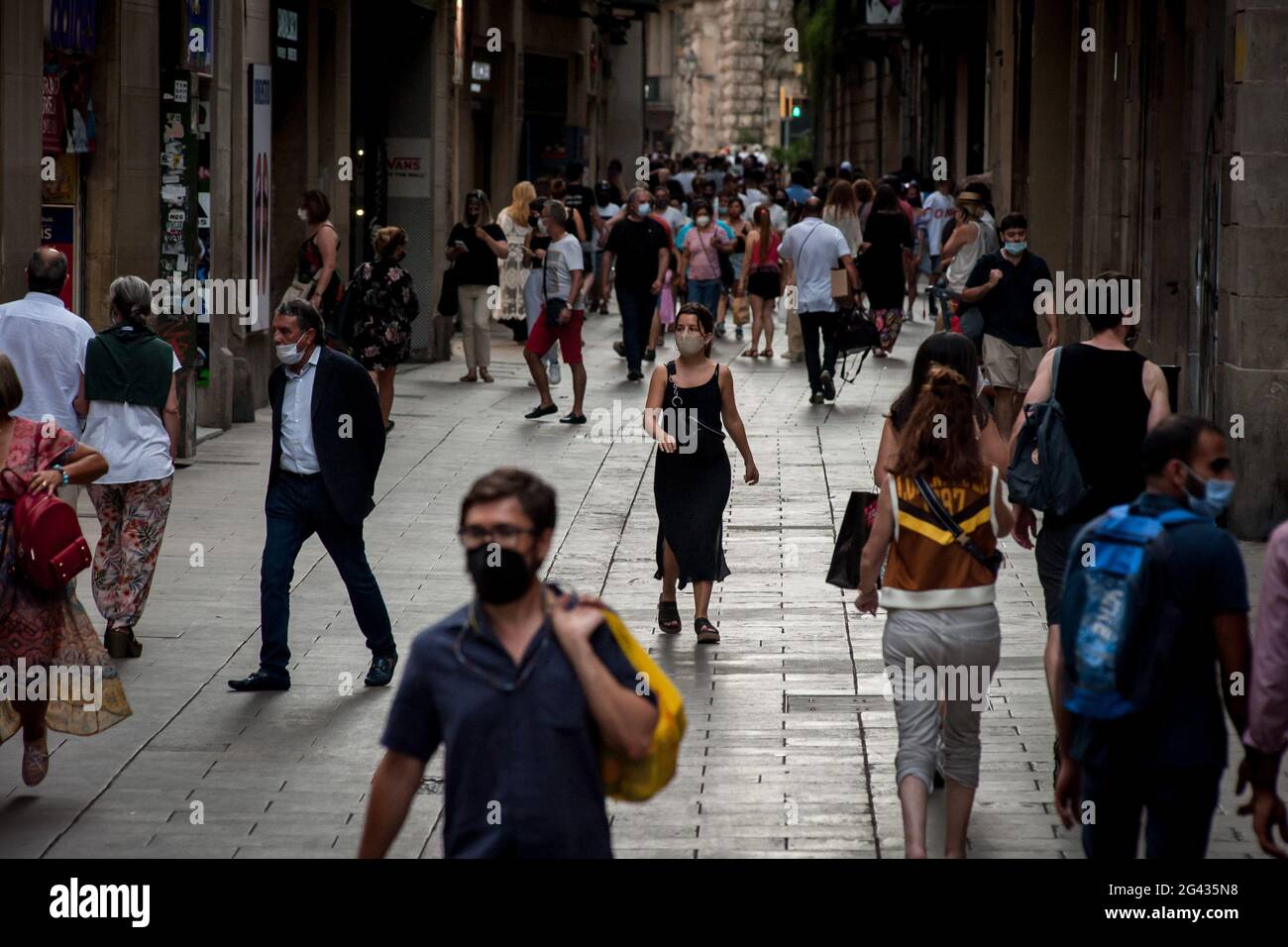 En ce vendredi après-midi, des personnes portant des masques pour empêcher la propagation du coronavirus se promènent dans la rue commerçante de Portaferrissa à Barcelone. L'utilisation obligatoire en Espagne de masques extérieurs prendra fin le 26 juin, a déclaré aujourd'hui le Premier ministre espagnol Pedro Sanchez. Banque D'Images