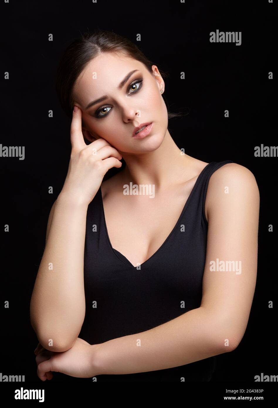 Portrait de beauté de la jeune femme. Petite fille Brunette avec maquillage de soirée et robe noire Banque D'Images