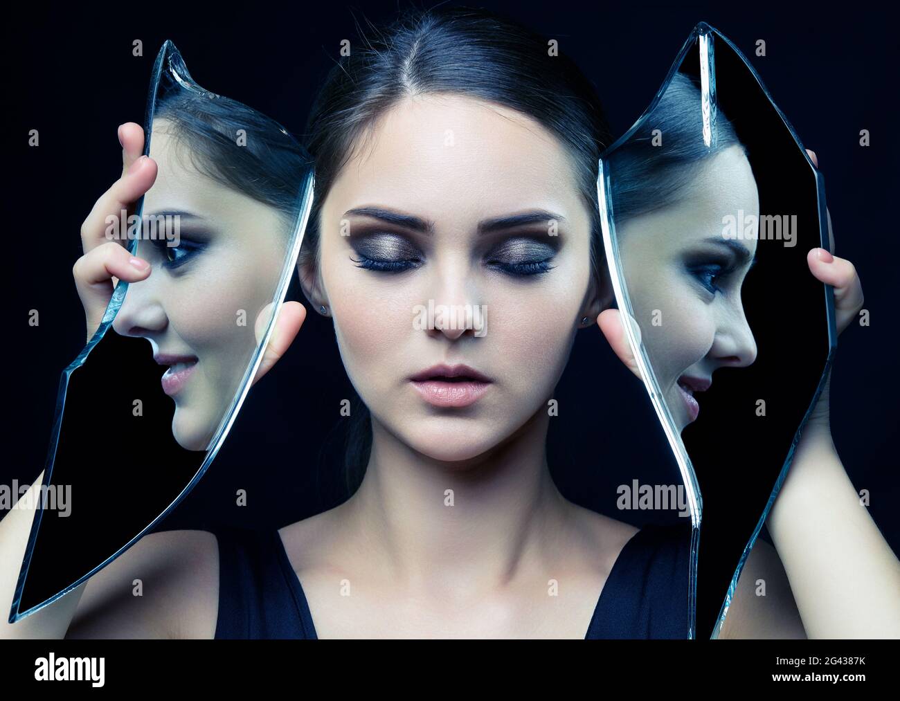 Jeune femme avec les yeux fermés et le miroir shard dans les mains. Banque D'Images