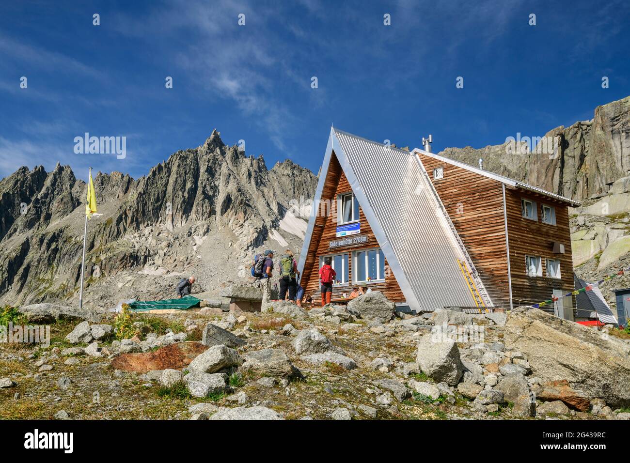 Plusieurs personnes se trouvent en face de la Sidelenhütte, Gross Furkahorn en arrière-plan, Sidelenhütte, Alpes Urner, Uri, Suisse Banque D'Images