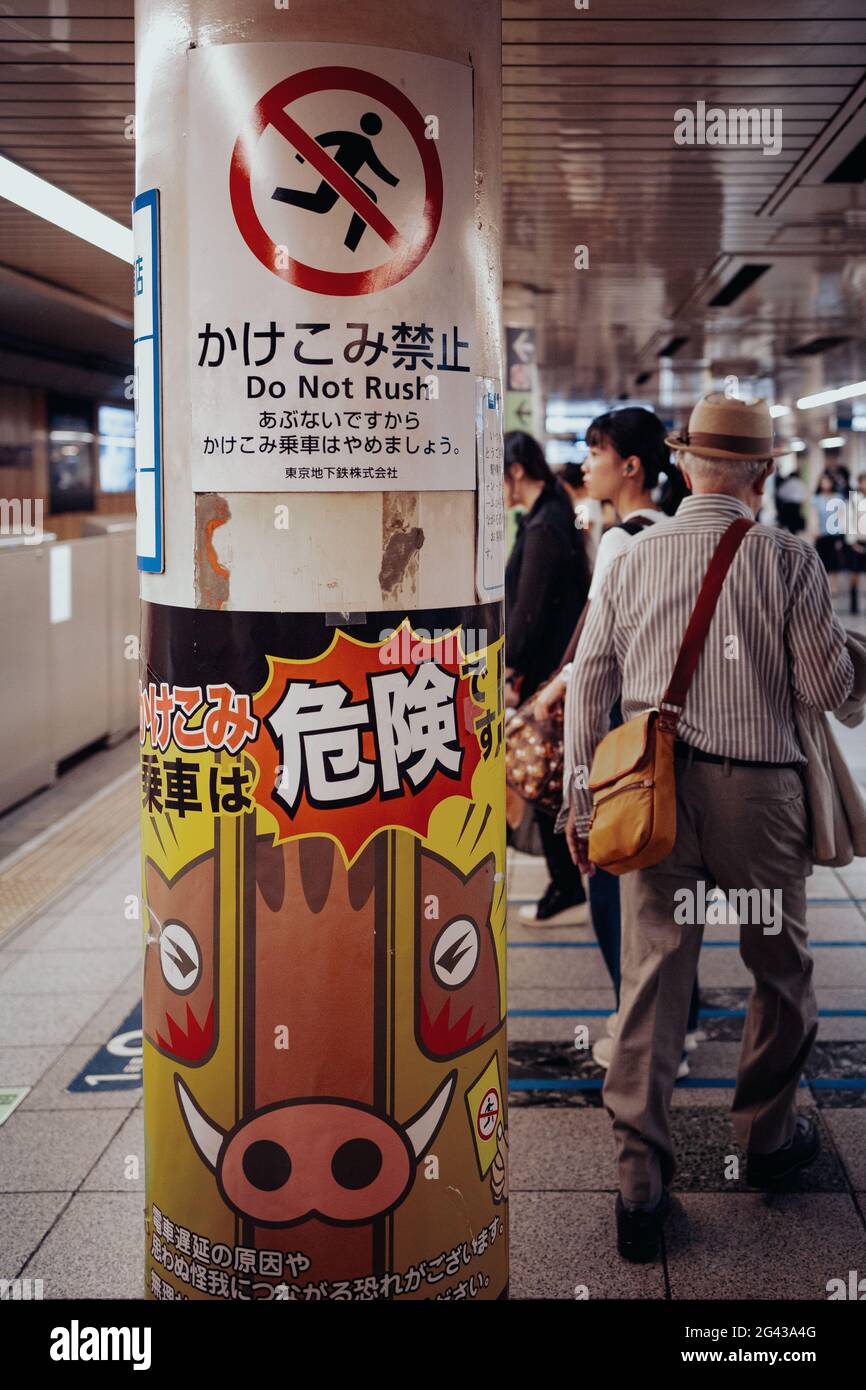 Les retraités du métro avec des avertissements au premier plan, Toyko, Japon Banque D'Images