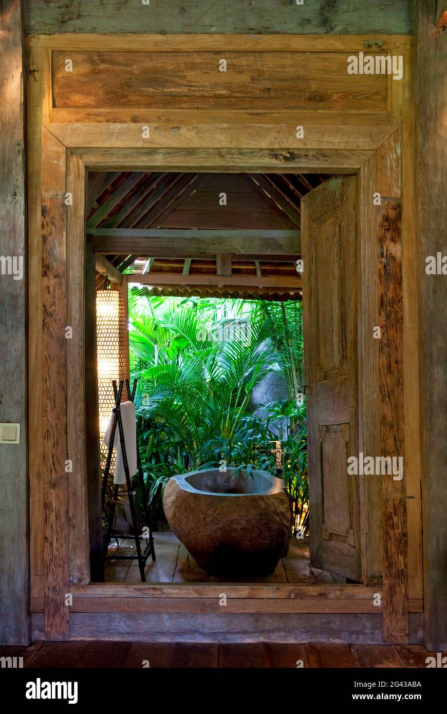 Baignoire en pierre située dans une salle de bains ouverte, dans une  ancienne maison en bois située dans la jungle. Bali, Indonésie Photo Stock  - Alamy