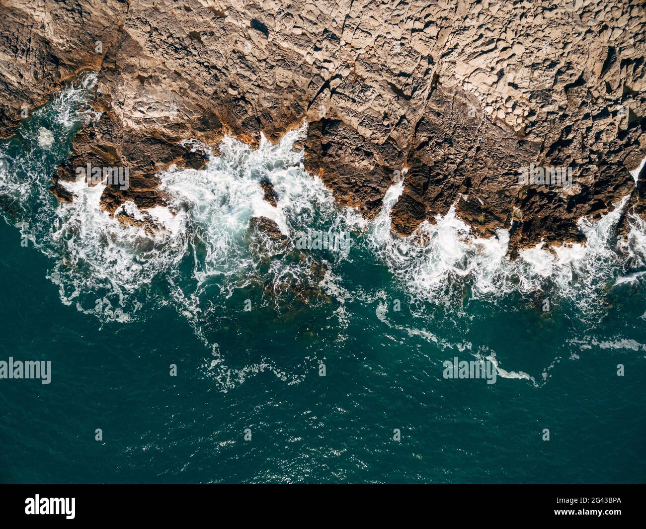 Drone aérien, vue de dessus des belles vagues de l'océan, s'écrasant sur la côte d'une île rocheuse. Banque D'Images