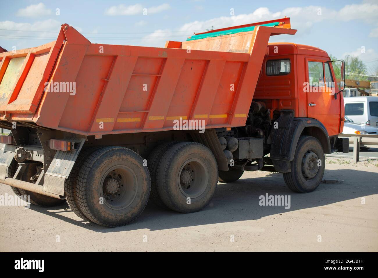 Le chariot est orange. Machine pour le transport de matériaux de construction en vrac. Le chariot est stationné. Machines de construction dans la ville. Banque D'Images