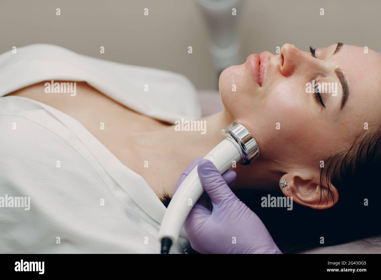 Jeune femme recevant un massage facial RF électrique au spa de beauté avec équipement d'électroporation. Banque D'Images