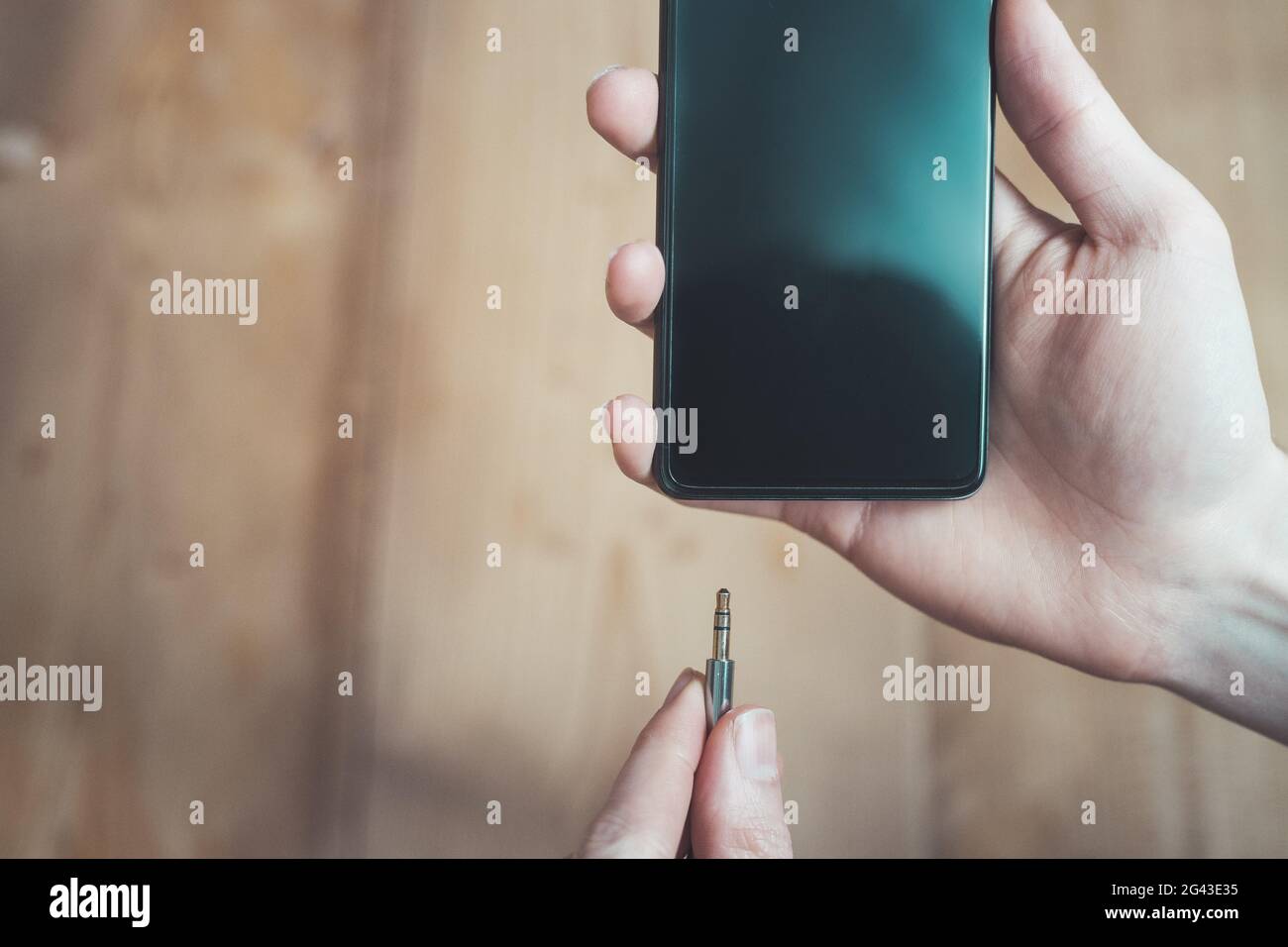 Concept de prise audio : connexion de la prise audio à un téléphone portable noir, gros plan Banque D'Images