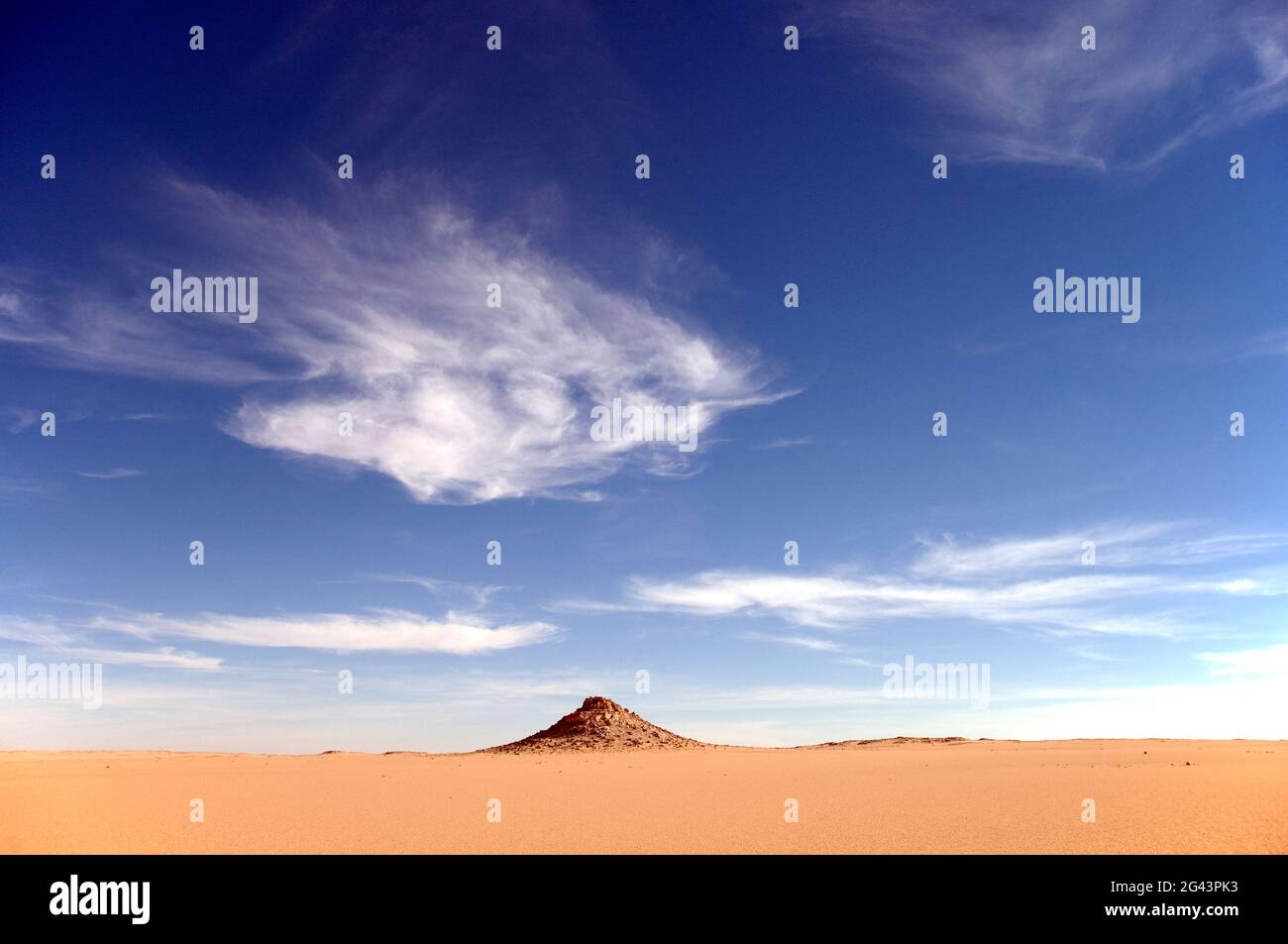 Un affleurement rocheux en grès sous des nuages blancs profonds dans la région du Sahara occidental, près du Gilf Kebir, dans le sud-ouest de l'Égypte. Banque D'Images